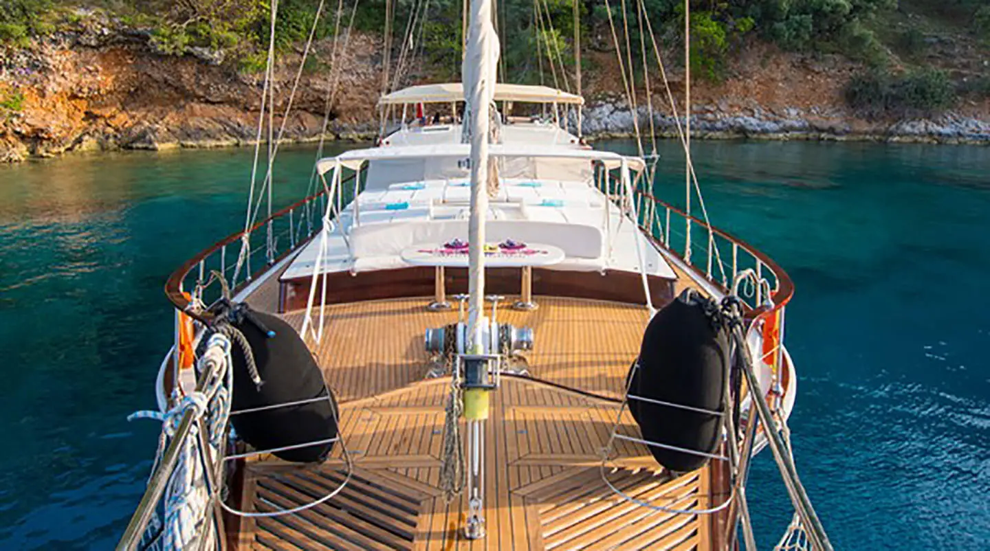 Mein Schatz sailing yacht deck with teak finish and seating, anchored near rocky coastline
