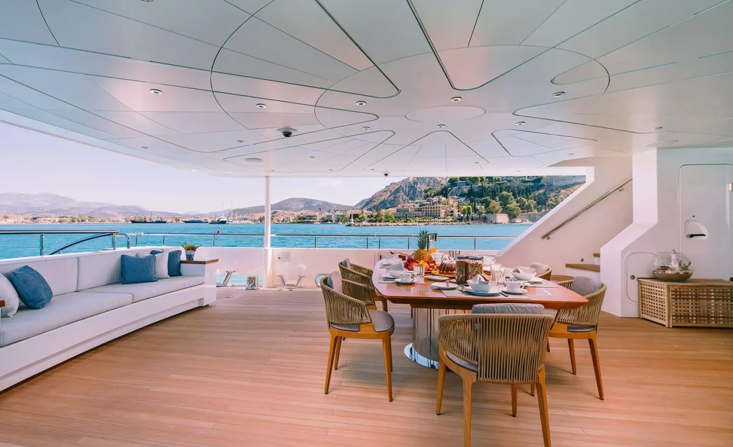 Xana motor yacht aft deck with seating area and sun loungers on wood deck