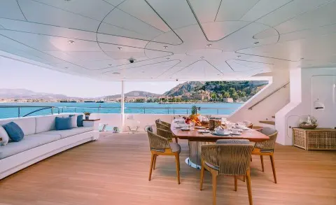 Xana motor yacht aft deck with seating area and sun loungers on wood deck