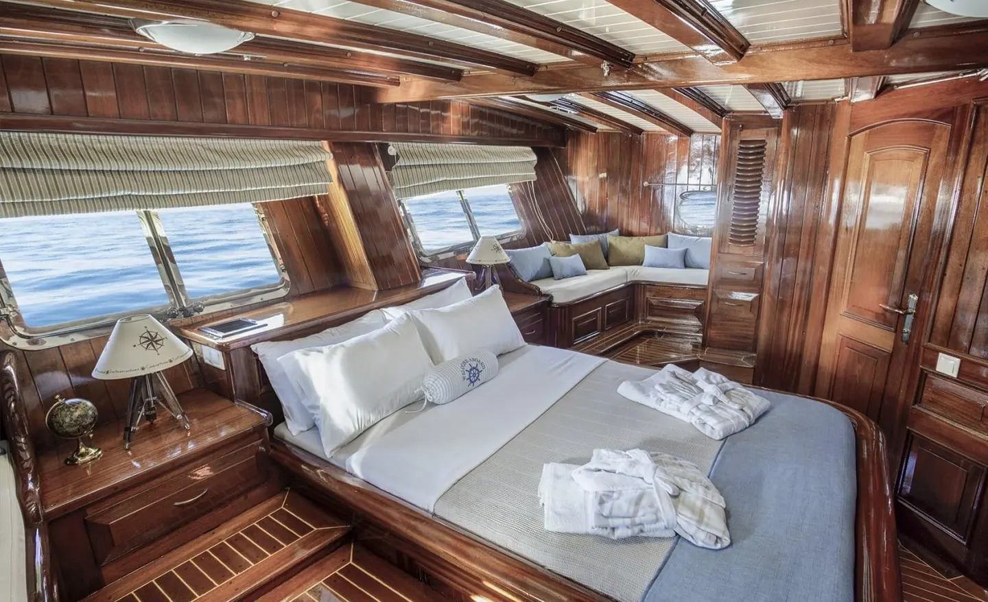 Luxurious yacht interior with wooden panels and a large cushioned seating area