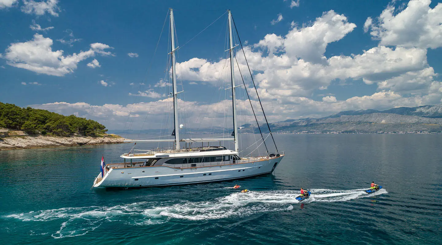 Navilux yacht sailing on blue sea with sails raised under clear sky