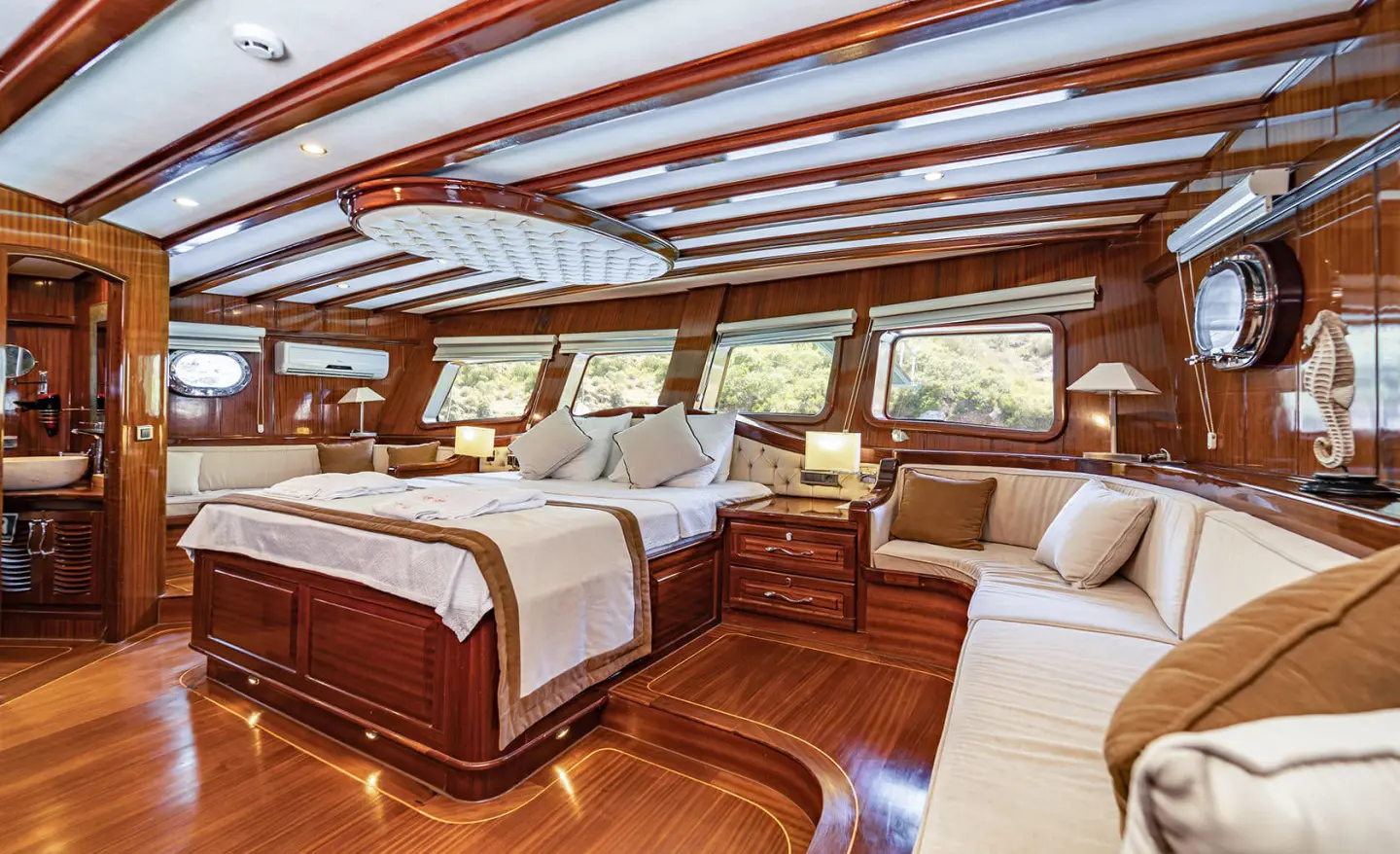 Lycian Queen yacht interior with wooden deck, sunlit seating and helm windows