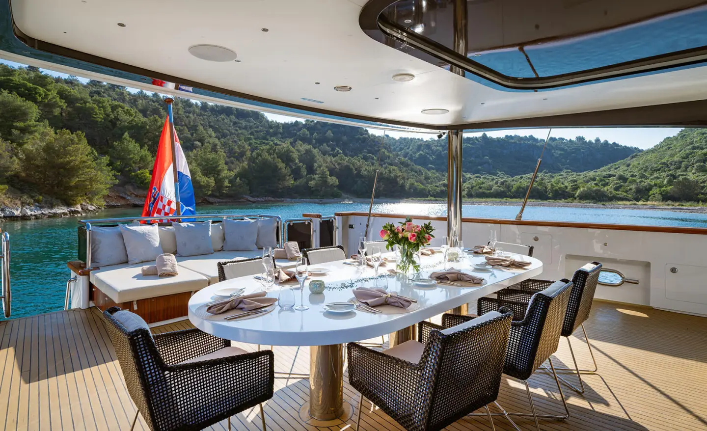 Navilux aft deck dining area with arranged table settings and scenic water view