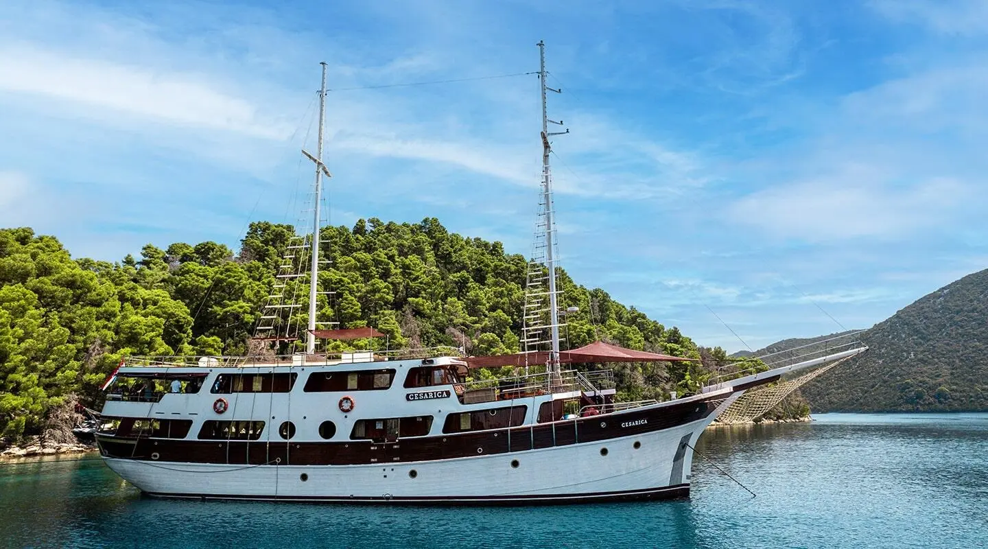 Cesarica luxury gulet yacht anchored near lush green hills under blue sky