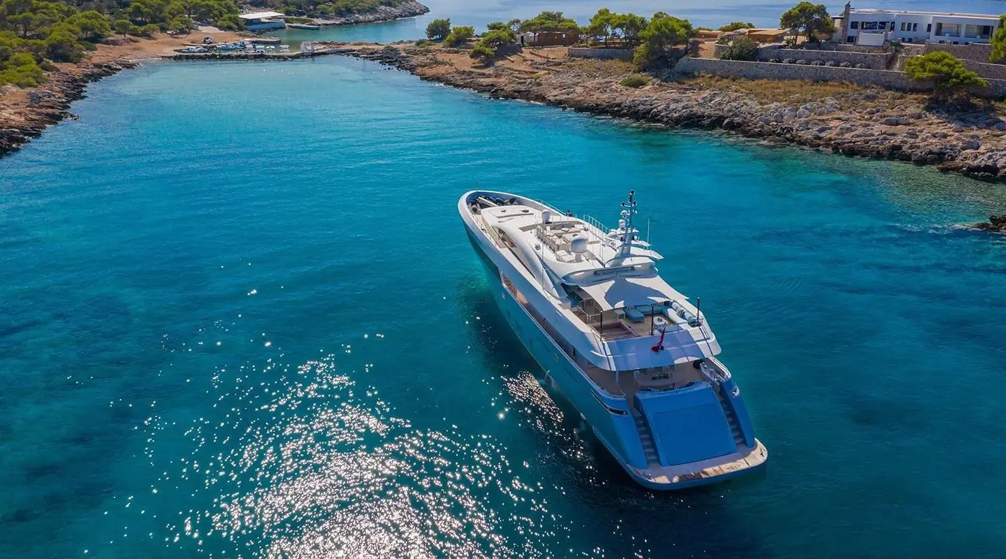Sea Wolf luxury yacht anchored in turquoise waters beside rocky coastline