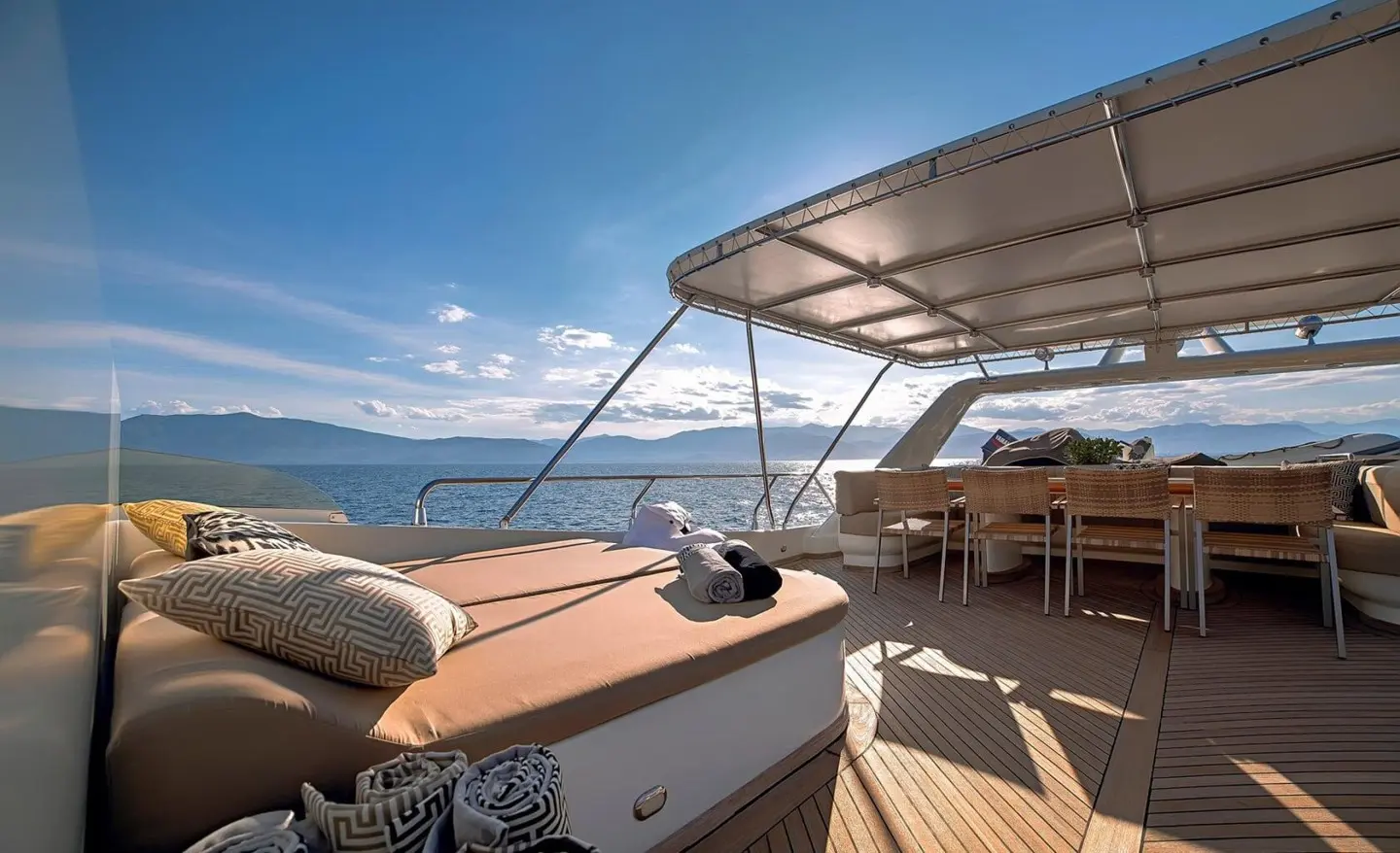 Aquila luxury yacht deck at sunset with seating and ropes on blue ocean