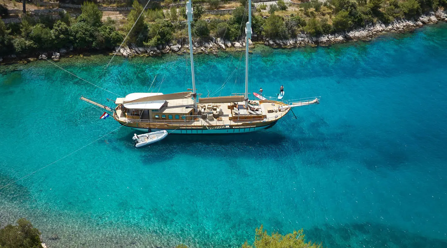 Gulet Libra anchored in turquoise water near shore