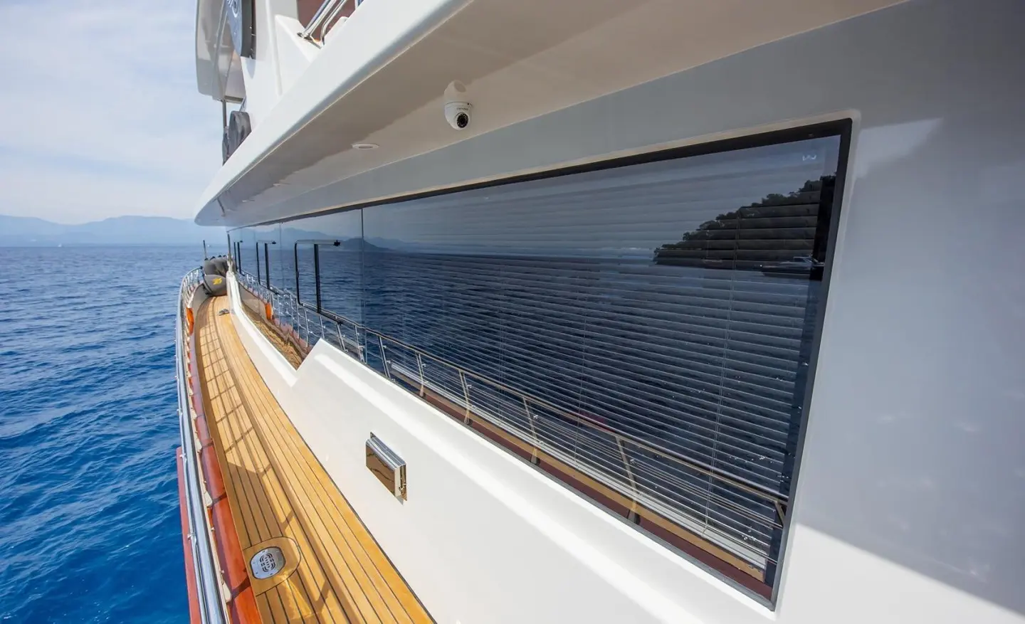Side deck view of Simay M motoryacht with blue hull windows and white superstructure