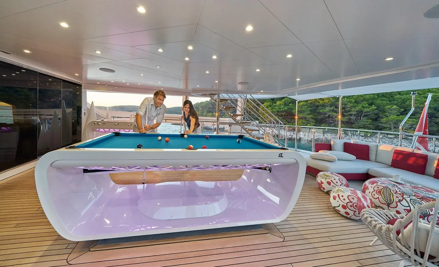 Happy Me motor yacht lounge area with wooden deck and seating under clear sky