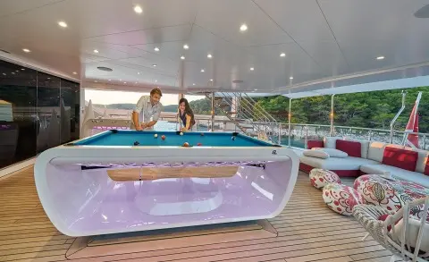 Happy Me motor yacht lounge area with wooden deck and seating under clear sky