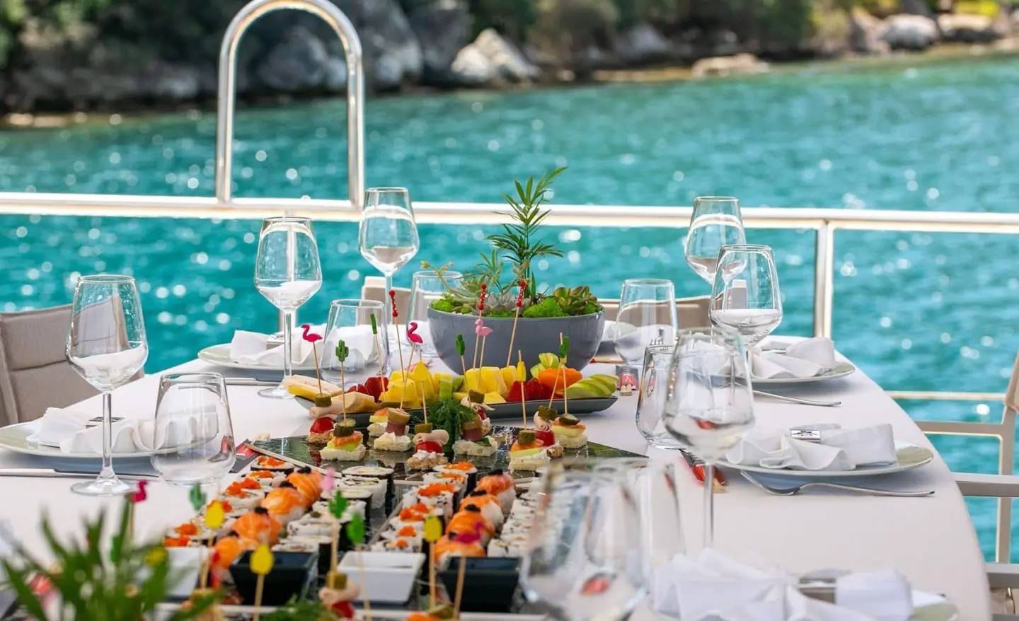 Table set for a yacht charter on clear turquoise water with festive appetizers