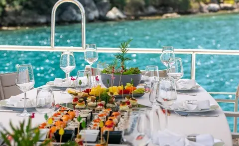Table set for a yacht charter on clear turquoise water with festive appetizers