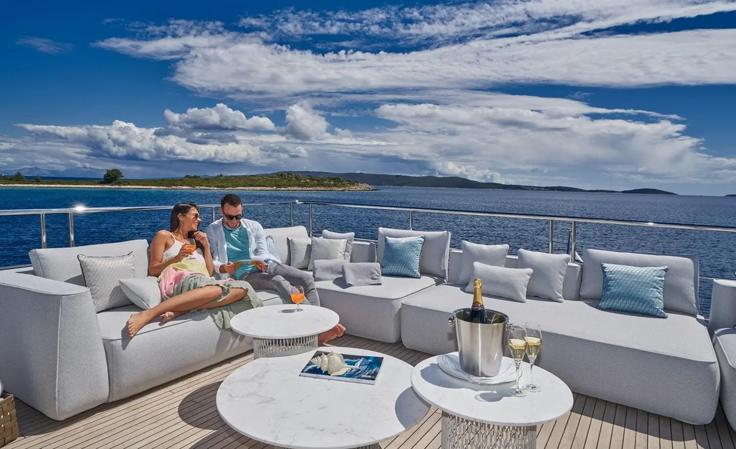 Yacht deck seating area on Aluminia Too during sunset with ocean view