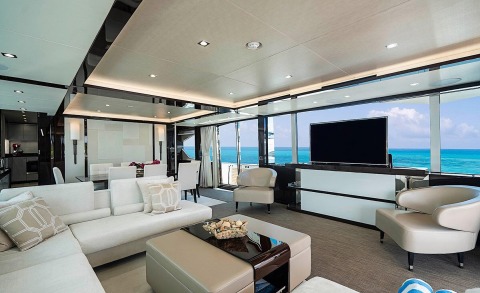 Quantum luxury yacht interior: bright salon with white seating, modern coffee table, sea views through large windows