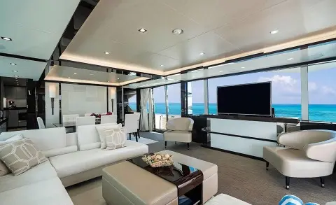 Luxurious yacht Quantum saloon with white seating, glass doors, and warm lighting