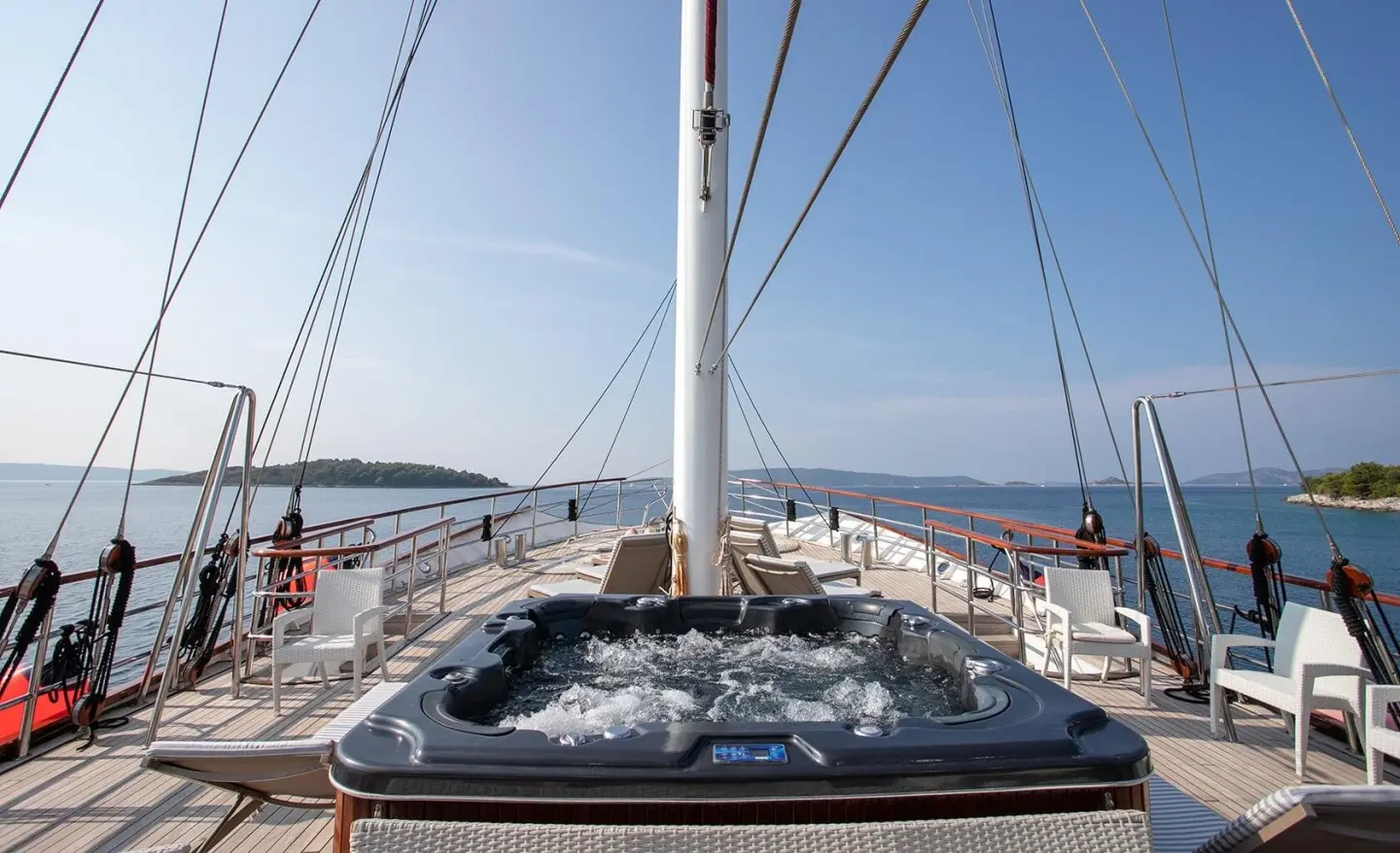 Amorena yacht deck with jacuzzi, sun loungers, and marina backdrop