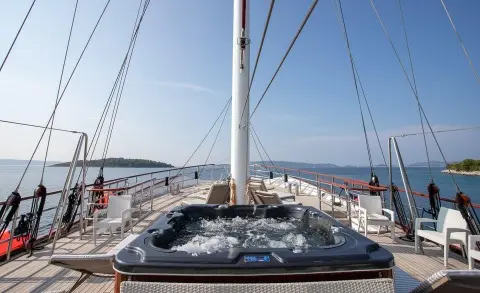 Amorena yacht deck with jacuzzi, sun loungers, and marina backdrop