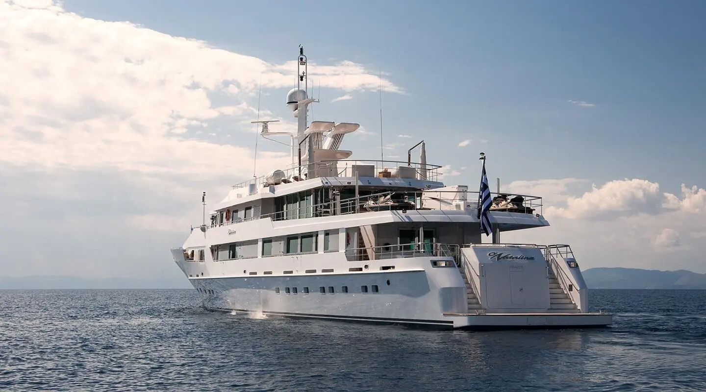 O'Natalina yacht anchored in calm sea, white hull, multiple decks, blue sky