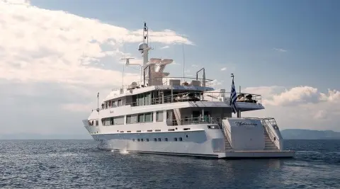 O'Natalina yacht anchored in calm sea, white hull, multiple decks, blue sky