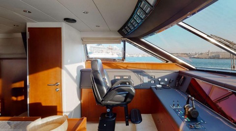 Luxurious yacht interior helm station on Lady Natassa with warm wood panels and expansive window view