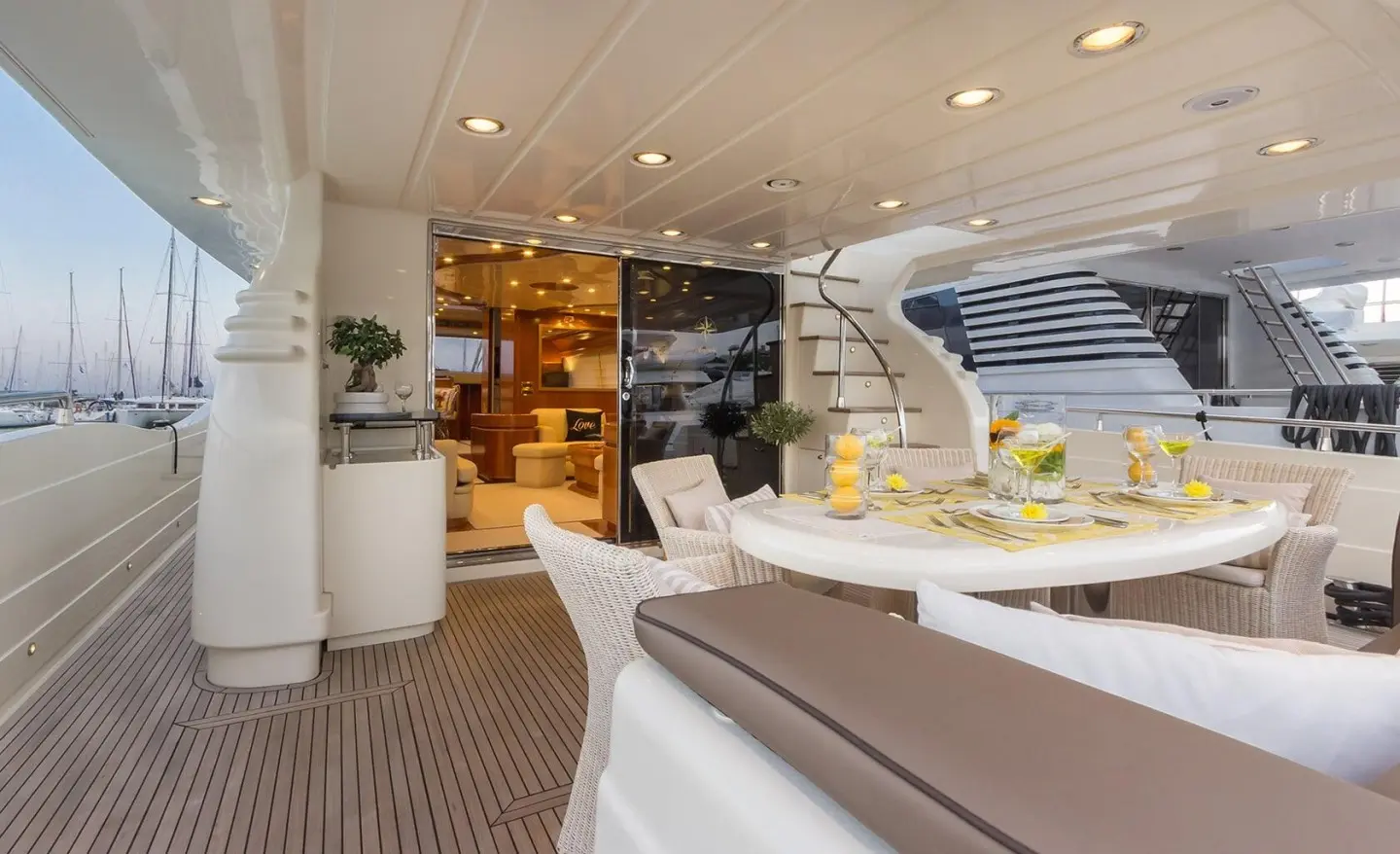 Amoraki motor yacht aft deck with seating, wood paneling and stairway