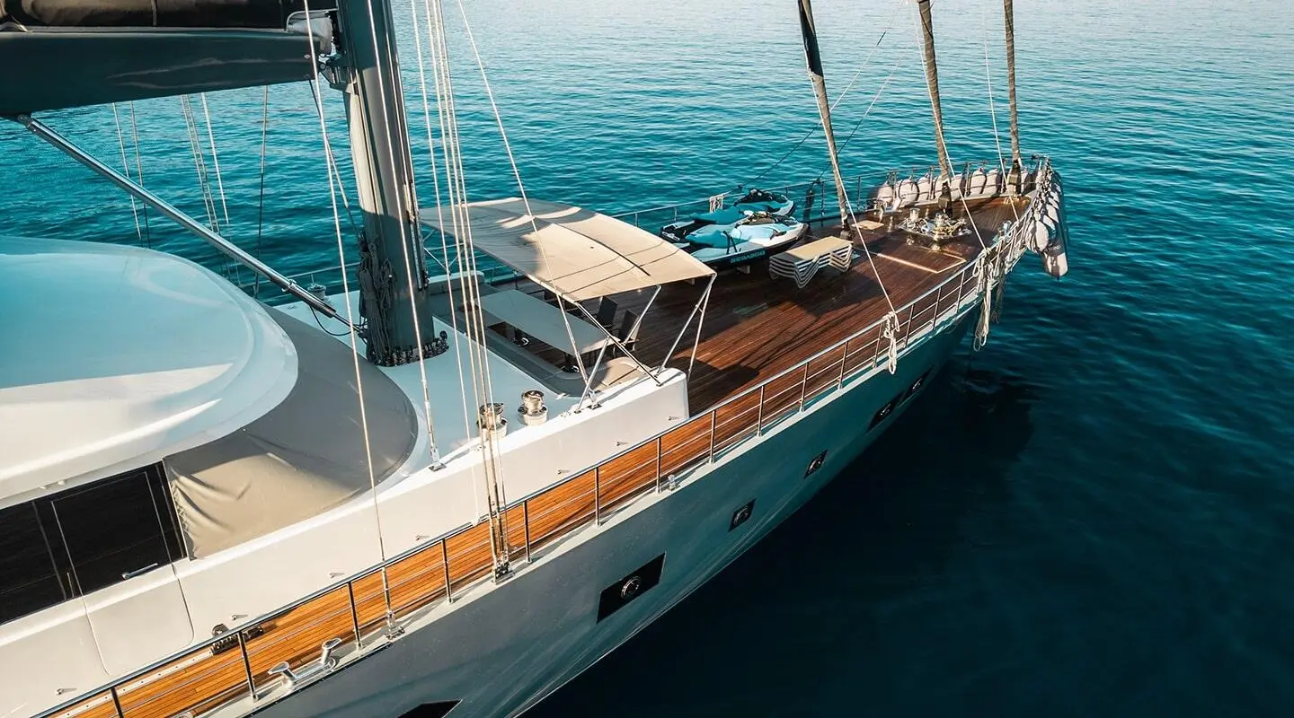 North Wind luxury yacht with teak deck and sun loungers anchored on calm blue waters