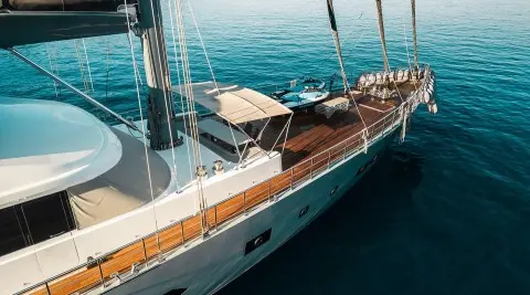 North Wind luxury yacht with teak deck and sun loungers anchored on calm blue waters