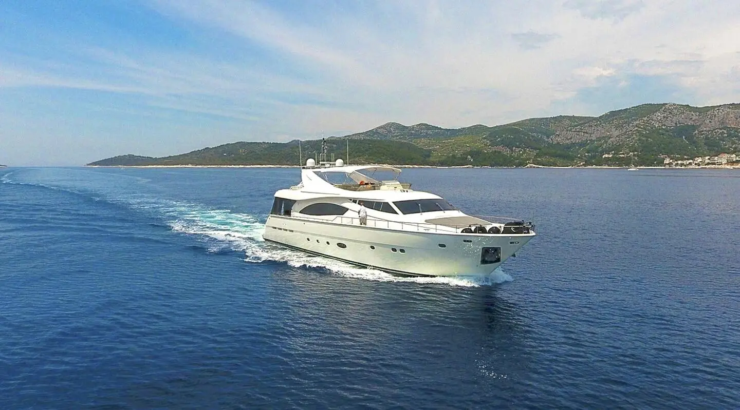 Miss Katariina luxury motor yacht cruising blue water with shoreline in background