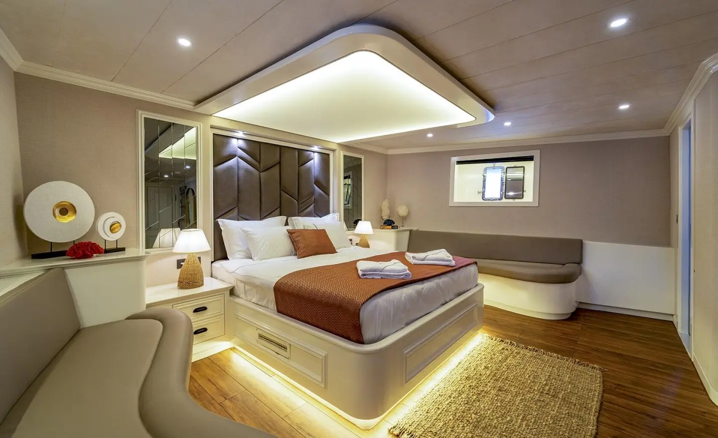 Queen Of Makri master cabin on gulet, bright interior with bed, seating, and warm lighting
