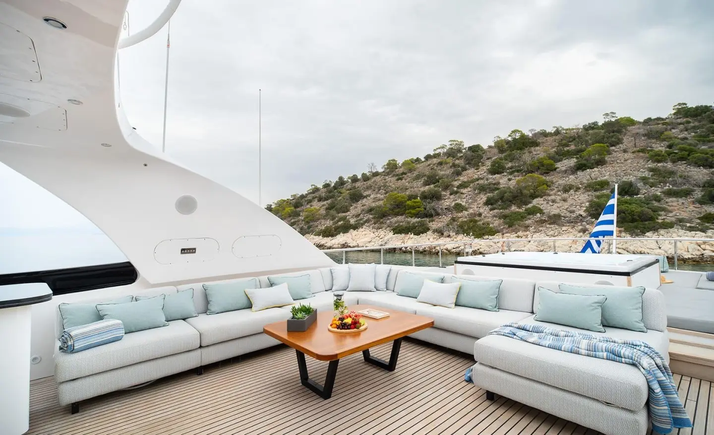 Pareaki II yacht flybridge seating area with a coffee table and ocean view
