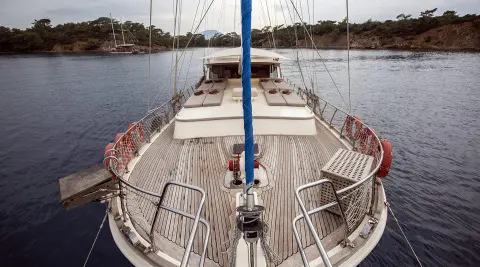 View from the bow of a gulet with wooden deck, ropes, and river water