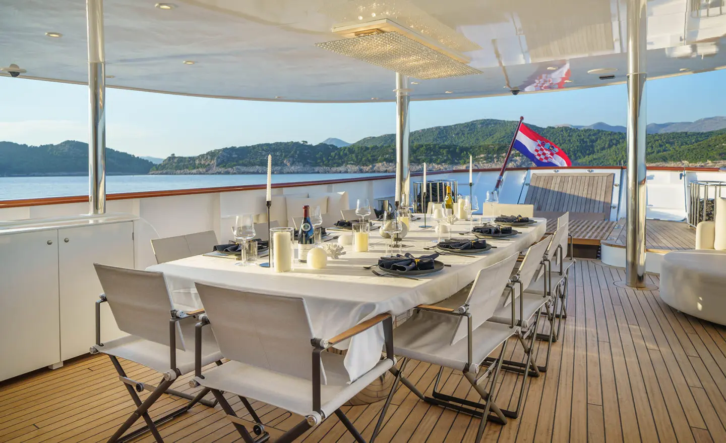 Maia yacht dining area on the open deck with tables and chairs