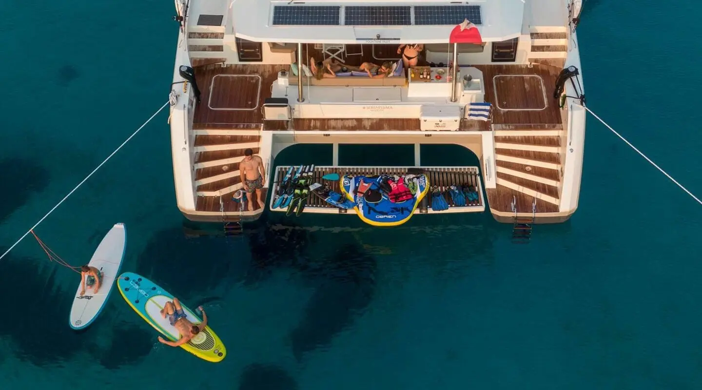 Overhead shot of Serenissima yacht with water toys on stern and blue sea