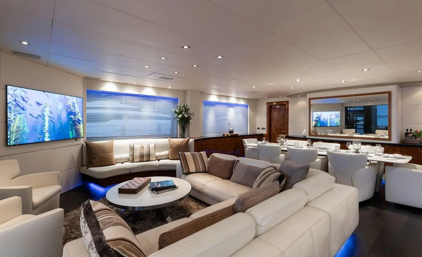 Luxurious yacht salon with seating, screens, and skyline view aboard Brooklyn