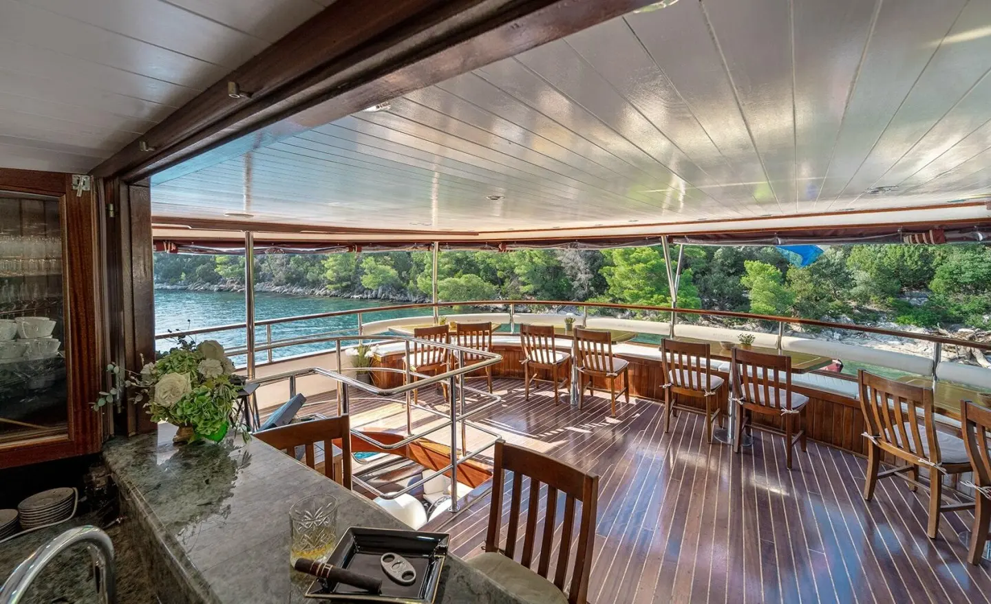 Open deck with wooden chairs and sea view, wooden floor on the aft deck