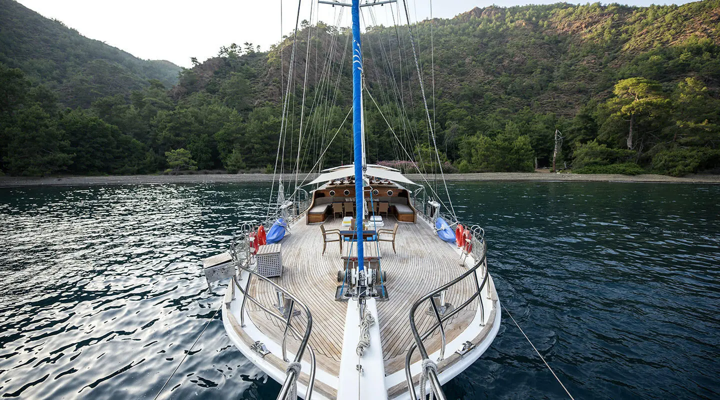 Kayhan 8 yacht bow view at sunset with calm blue sea and hills