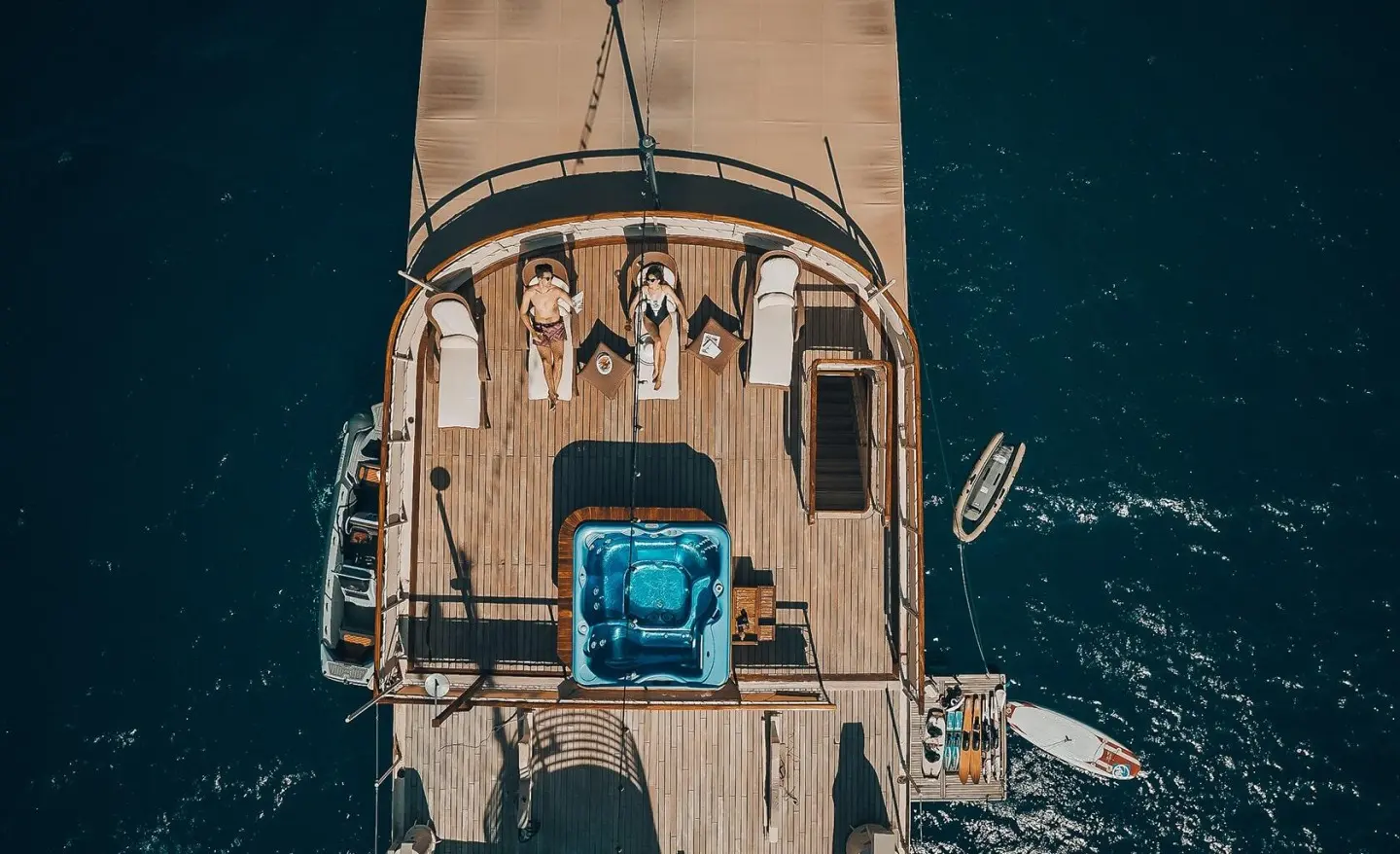 Aerial view of Seagull II yacht deck with sun loungers and a blue spa tub on teak decking
