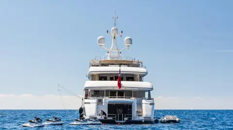 Apogee yacht on calm sea at sunset, rear view showing stern and deck