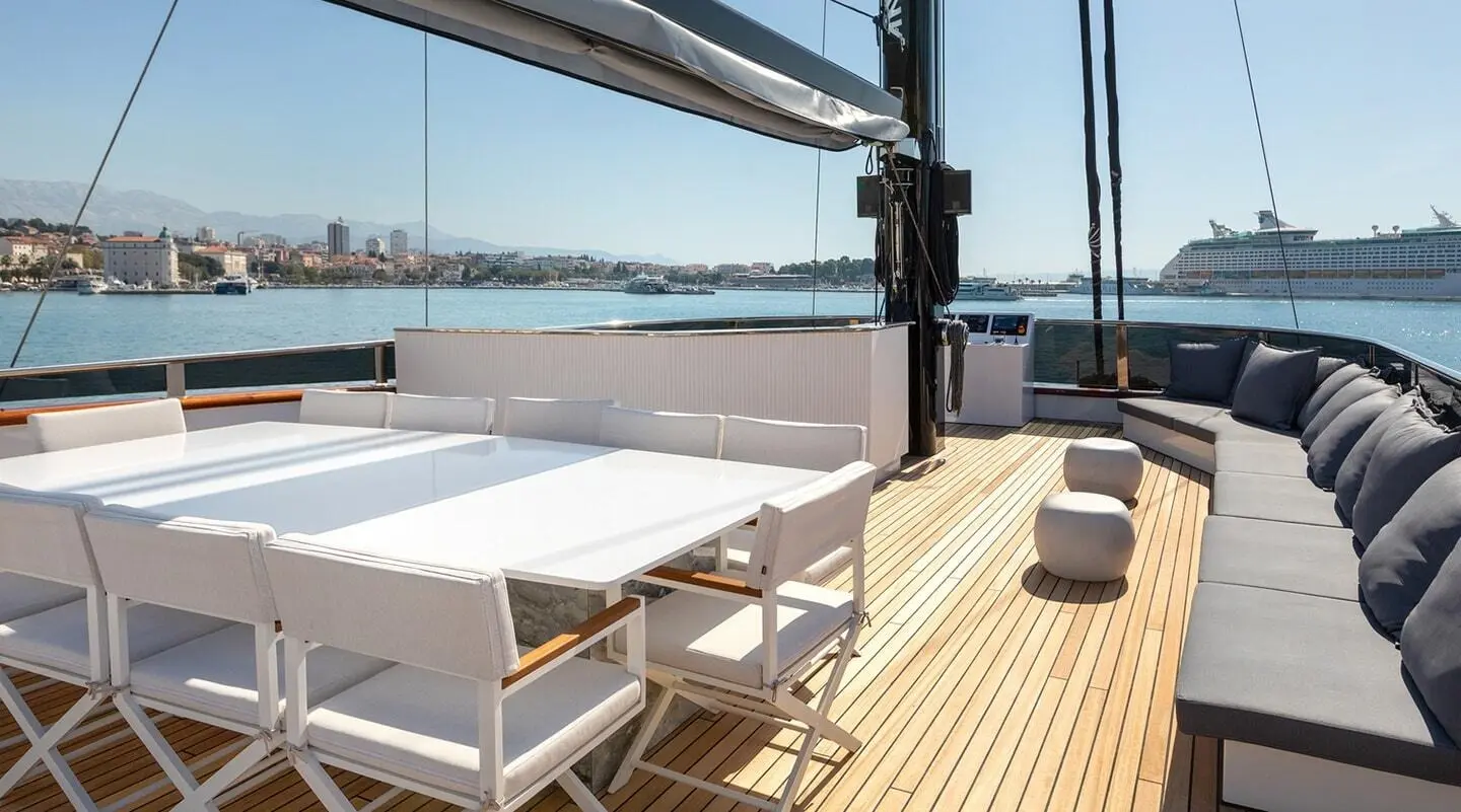 Scorpios yacht sun deck with white table and chairs on wooden deck