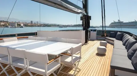 Scorpios yacht sun deck with white table and chairs on wooden deck