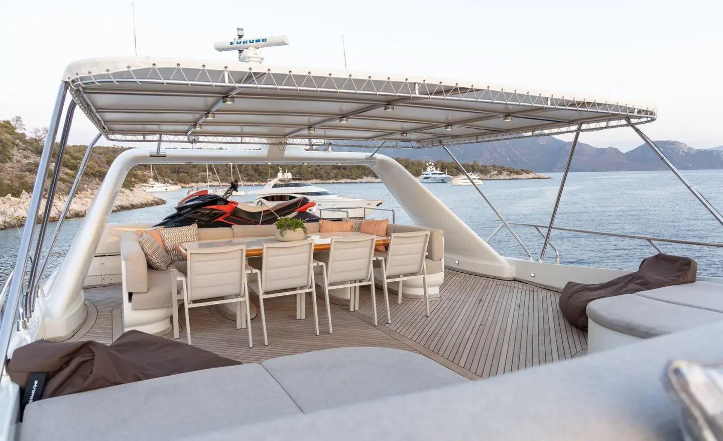 Aquila motor yacht flybridge with seating, table, and ocean view