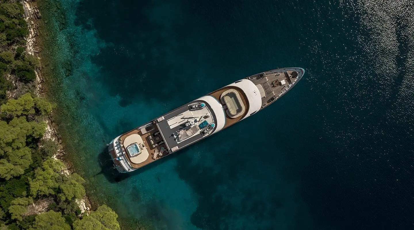 A sleek luxury motor yacht named Freedom sails calm blue water