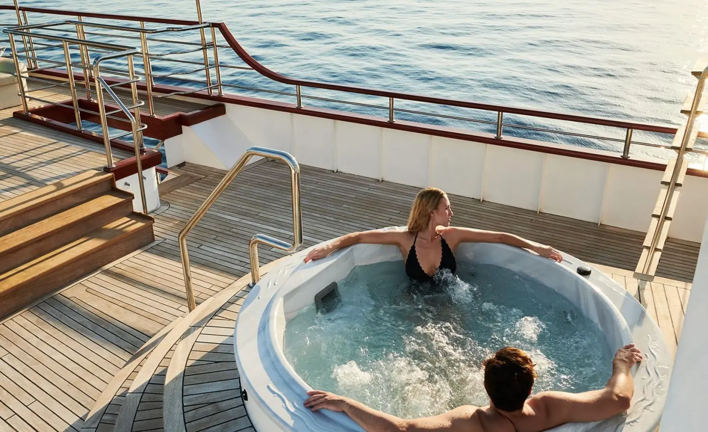 Corsario luxury gulet sailing at sunset with people in a hot tub on deck