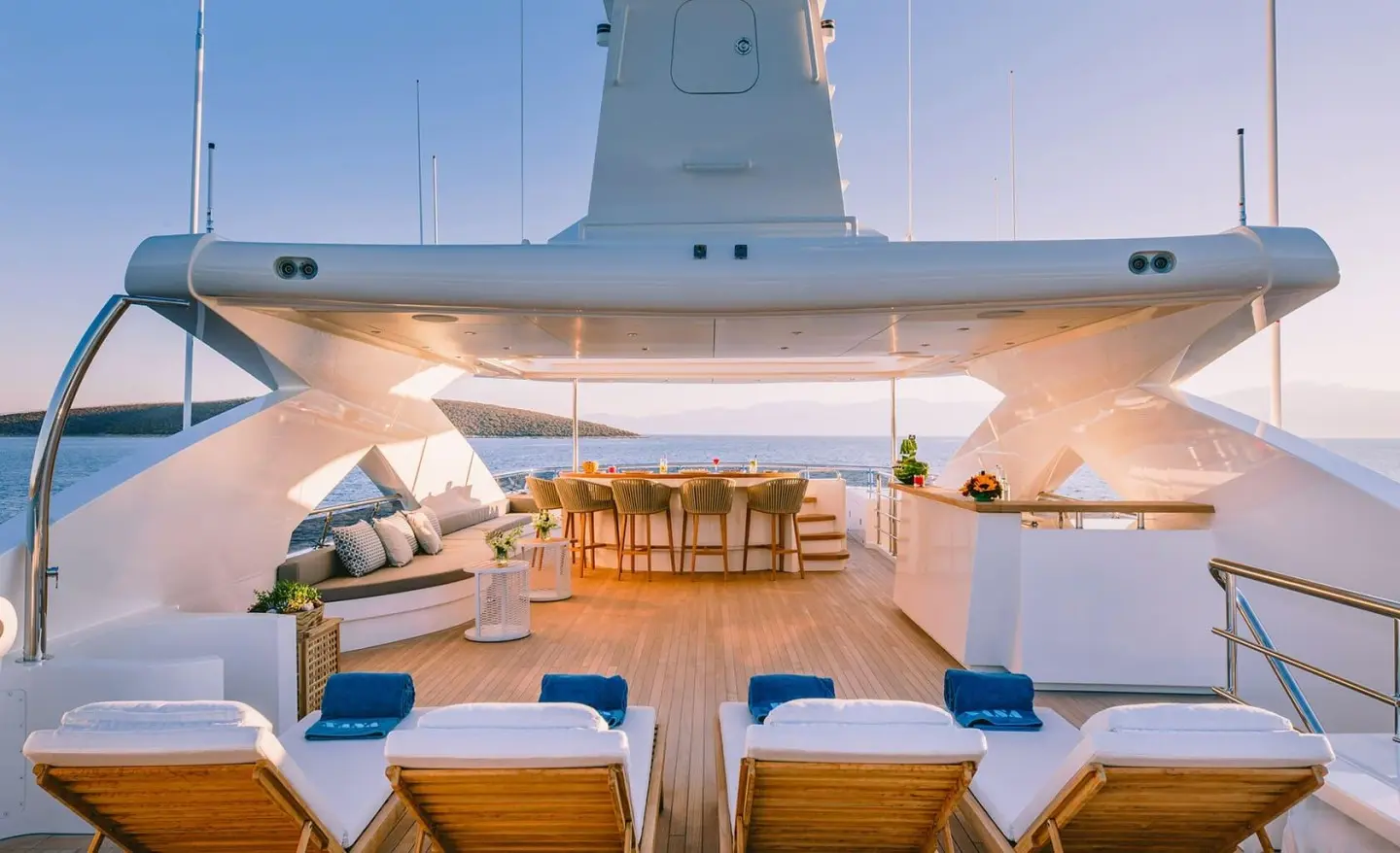 Xana luxury yacht deck with seating, bar, and sun loungers overlooking calm seas