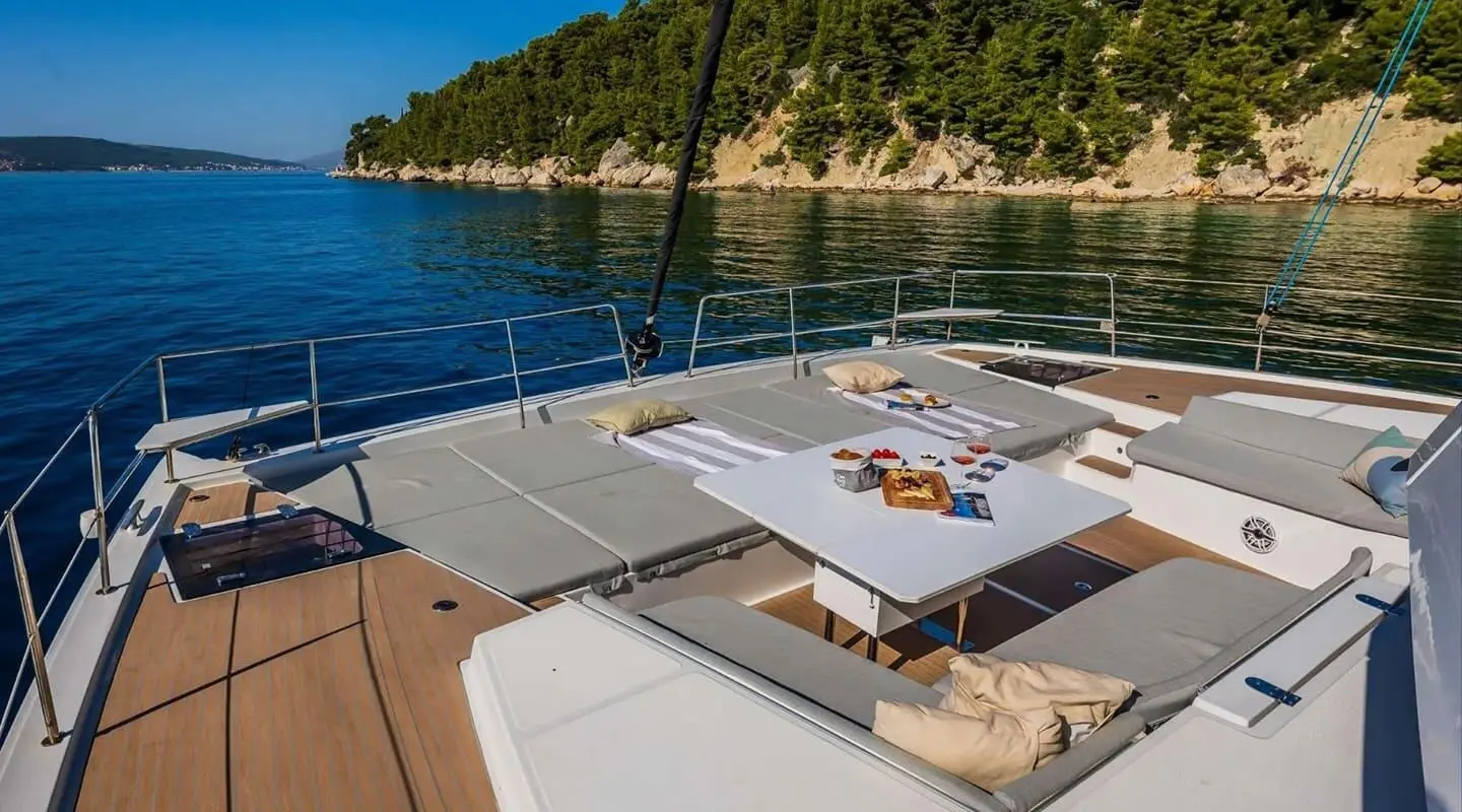 Ocean Lounge yacht bow deck with seating area and a table on a sunny day