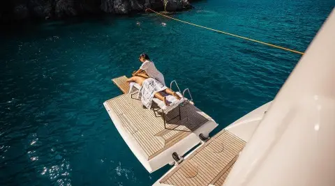 Top-down view of Angelo III yacht anchored near rocky coast at sunset