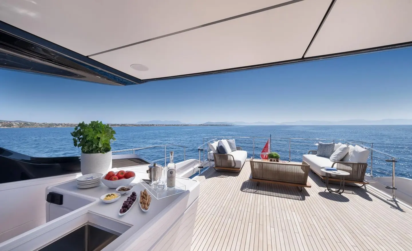 Spica yacht flybridge overlooking blue sea with seating and sun loungers