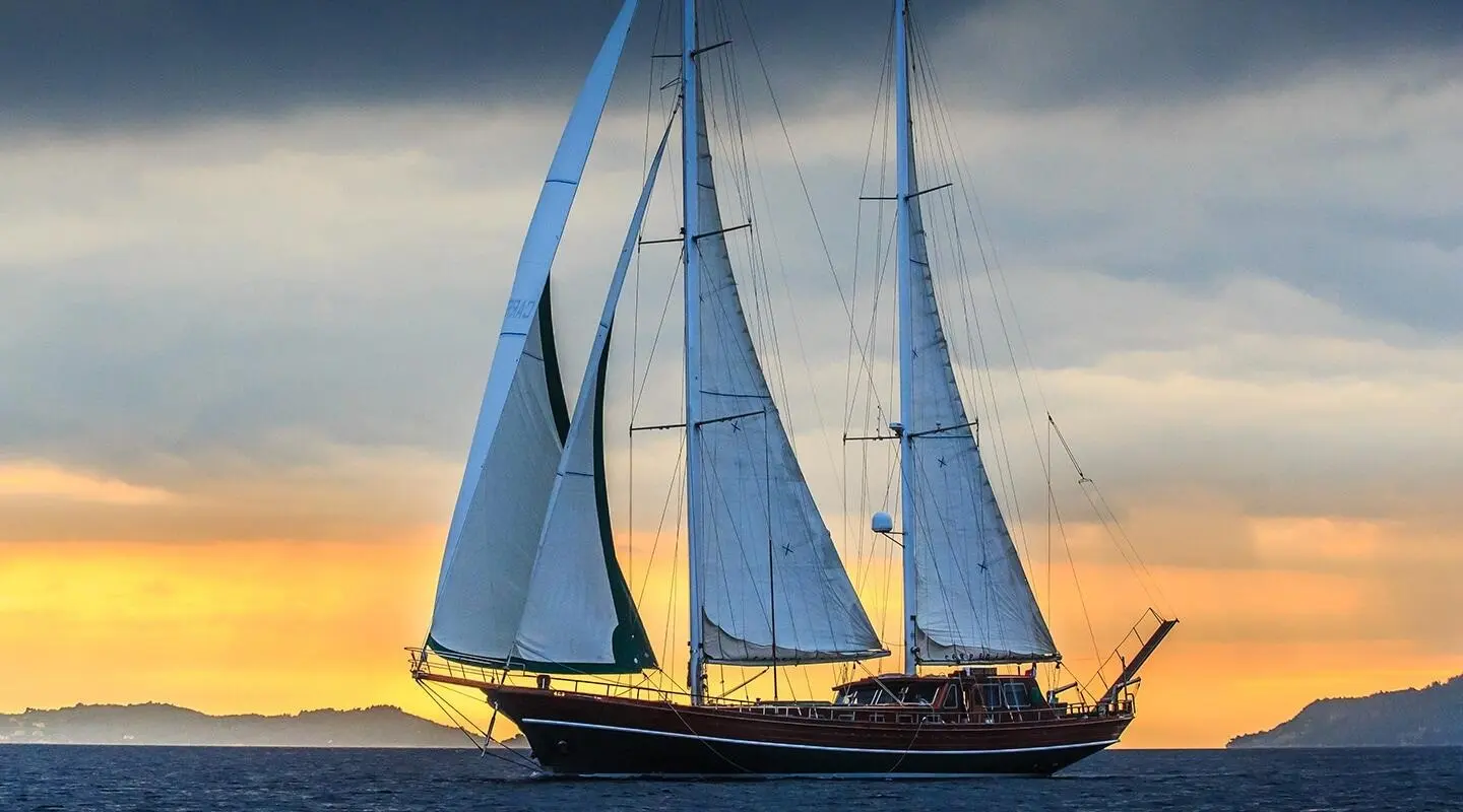 Carpe Diem 7 luxury gulet with tall sails on calm sea at sunset