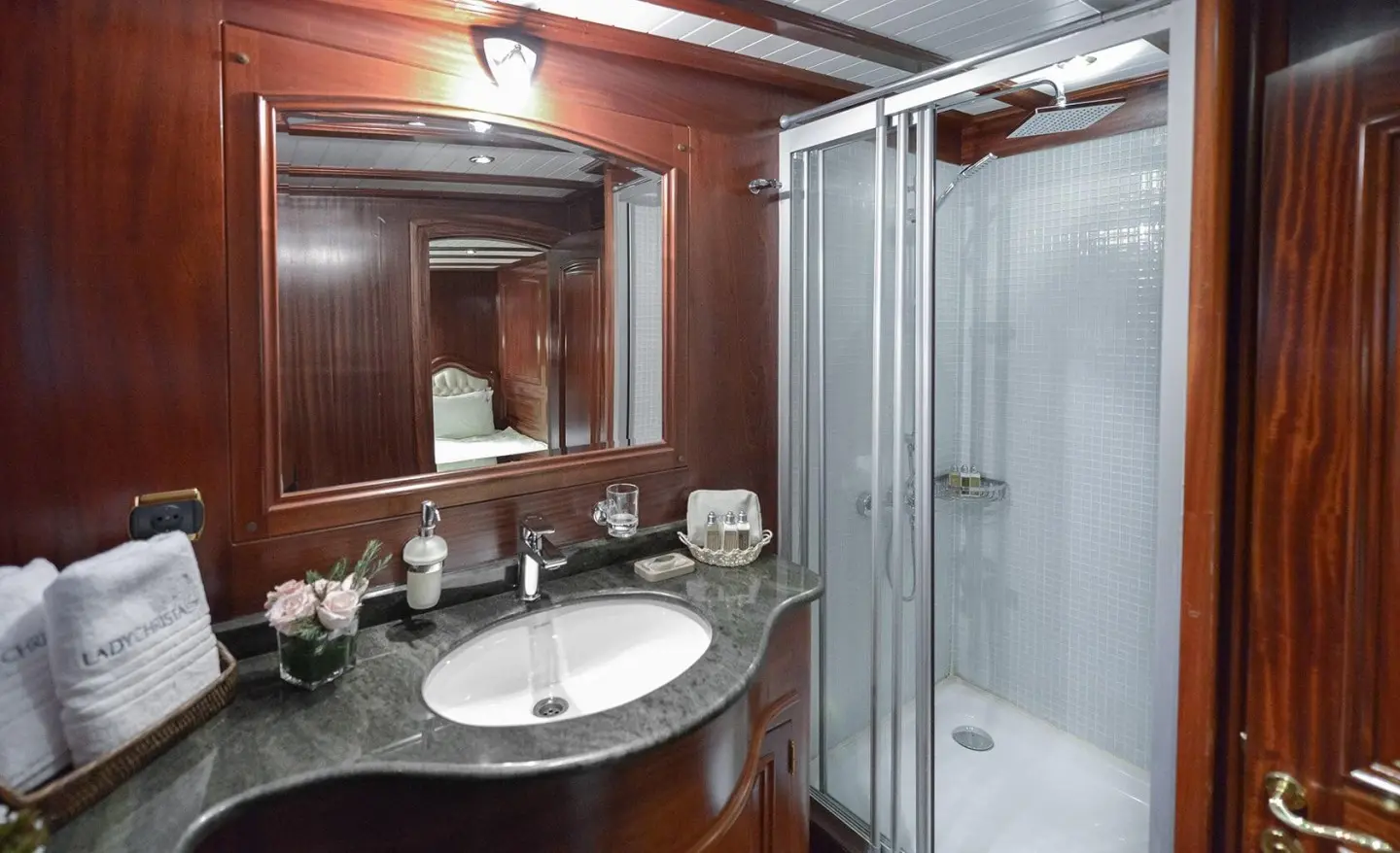 Lady Christa yacht vanity area with wooden paneling and glass shower