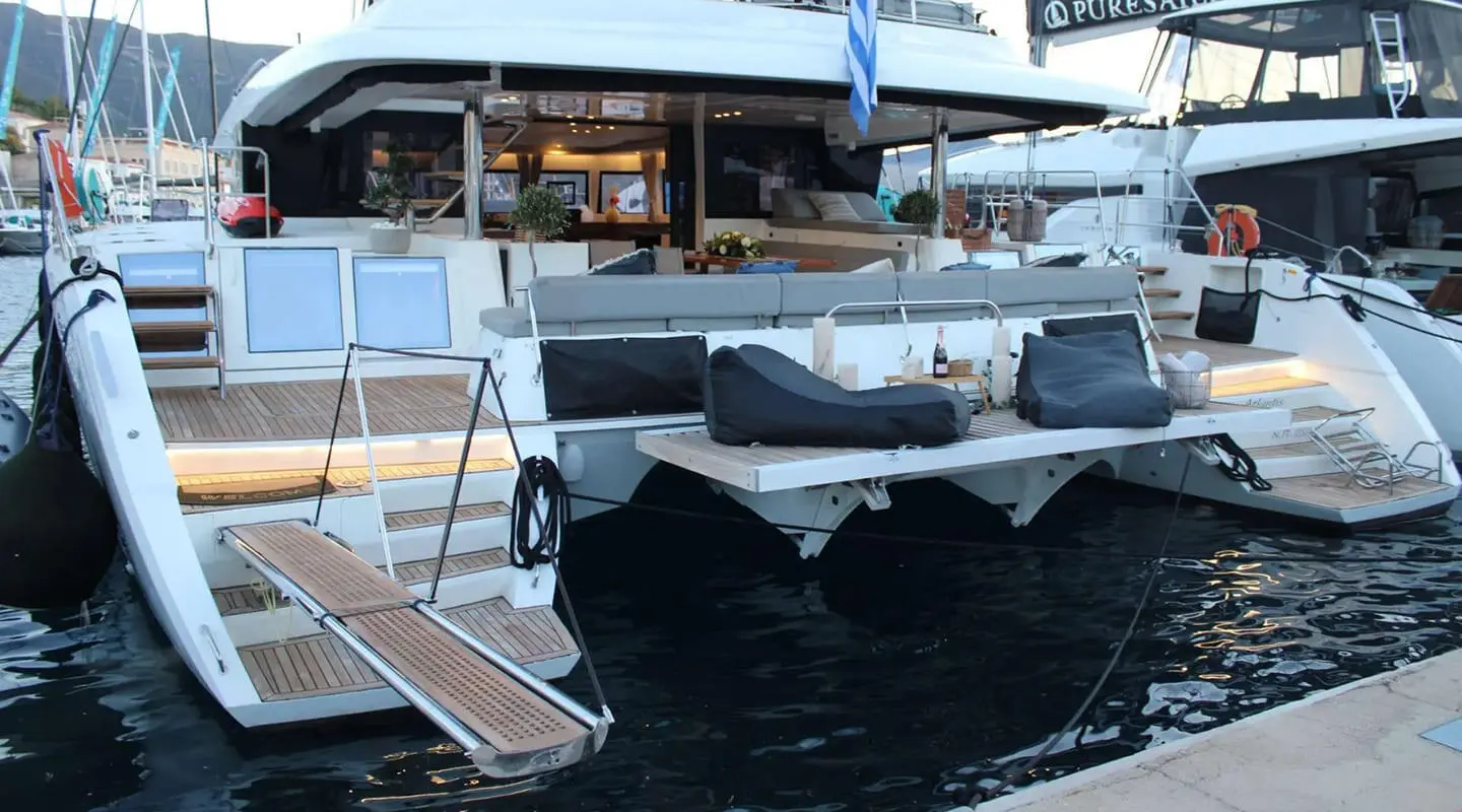 Yacht Atlantis docked at marina with wooden gangway and glass railings